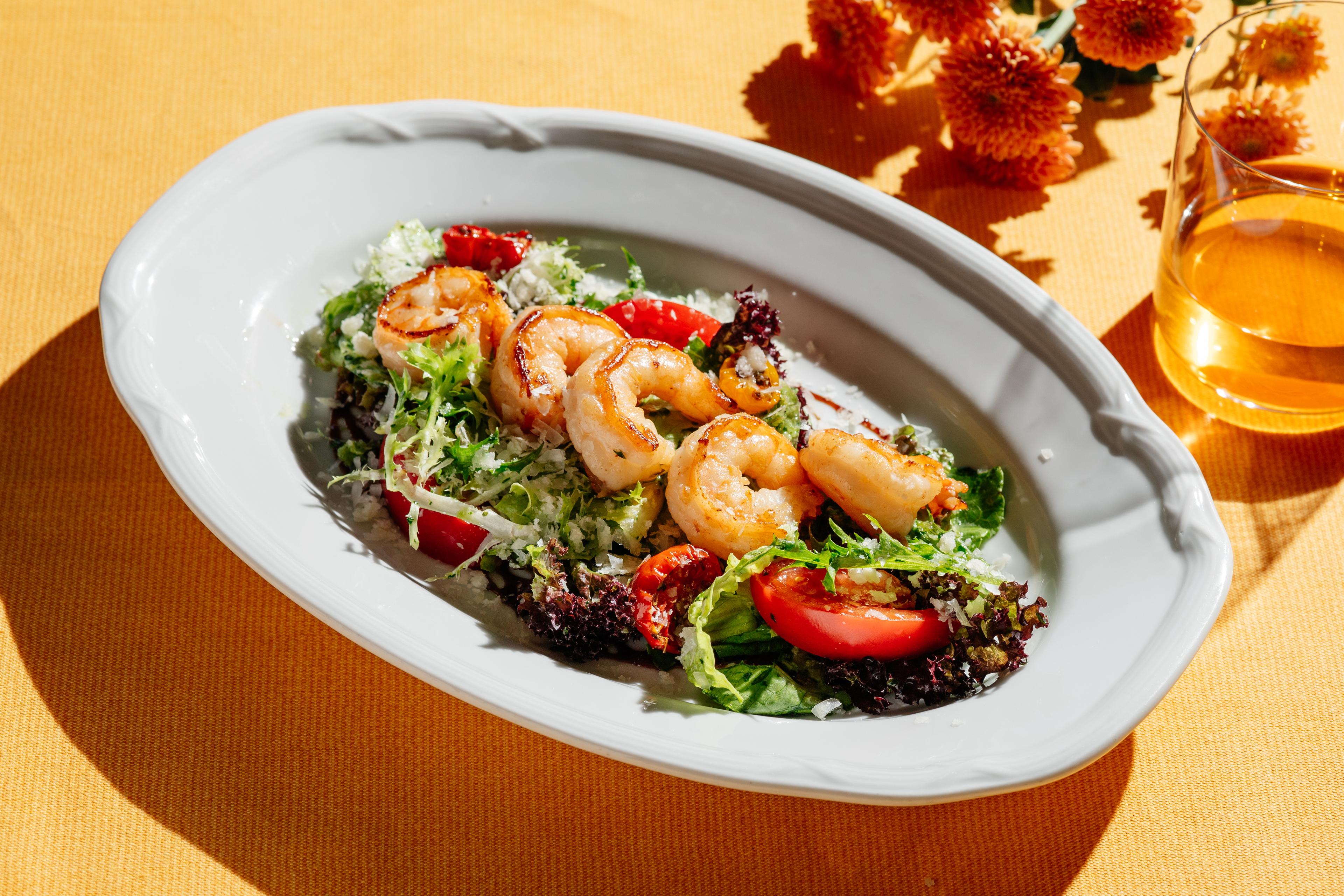 Листья салата с креветками, томатами и соусом сальса верде